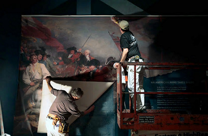 工人正在悬挂一幅邦克山战役的绘画作品，为博物馆的开幕做准备工作。图片来源：Jacqueline Larma/AP